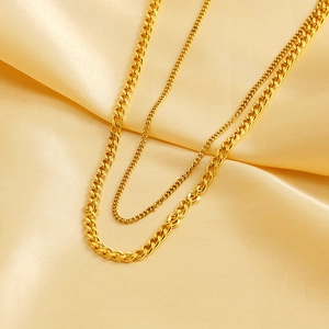 Double-layered gold-plated stainless steel Cuban link necklace on golden silk background