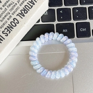 Close-up of spiral phone cord hair tie with blue and purple floral patterns on a desk