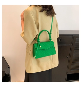 Groene crossbodytas van reliëfleder op model met gouden metalen kettingdetails