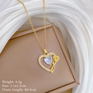 Detailed view of heart pendant necklace with gold rose and crystal on jewelry box