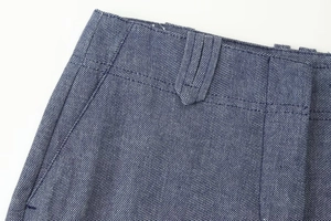 Makroansicht der blauen Fischgrät-Stofftaille und der Nähte an der Hose