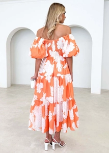 Detail of elegant orange floral dress showing bubble sleeves and elastic smocked back design