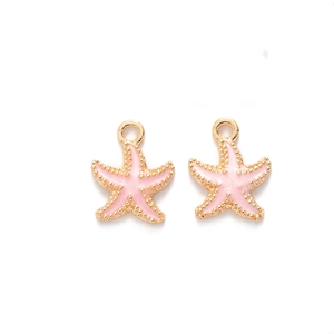 Pair of gold-edged pink enamel starfish charms with dotted texture on white background