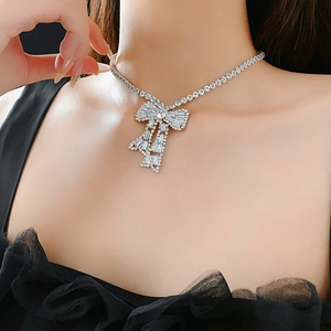 Macro shot of a silver bow necklace with diamonds worn on a neck for luxury jewelry look