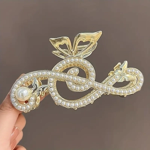 Golden musical note hair claw clip with elegant pearls and butterfly accents on dark background