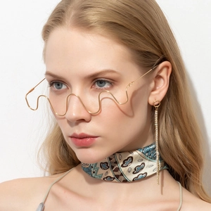Close-up of wavy gold metal half-frame decorative glasses without lenses for high fashion