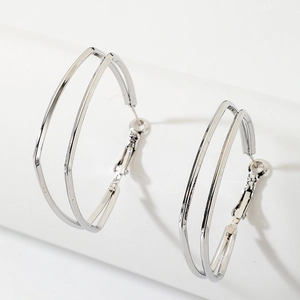 Close-up of silver geometric double-layer hoop earrings with polished metallic finish