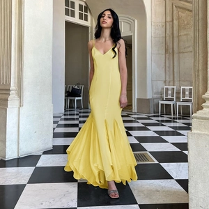 Détail de la robe longue jaune dos nu moulante avec ourlet à volants et queue de sirène