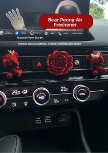Detail of red bear and peony flower car aroma diffusers on a dashboard vent