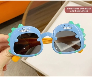 Detail of blue cartoon dinosaur sunglasses with grey lenses and orange temples for kids
