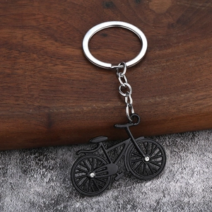 Detailed close-up of a black alloy bicycle keychain featuring intricate metal spokes and frame