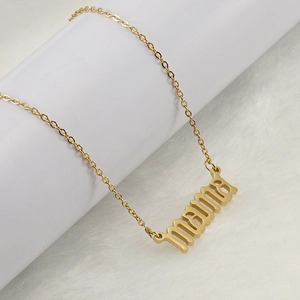 Golden stainless steel necklace featuring a MAMA pendant on a soft plush background
