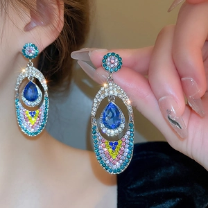 Silver crystal butterfly tassel earrings with blue teardrop gemstone on model