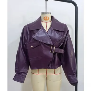 Détail de la veste courte en similicuir violet avec col à revers et ceinture bouclée