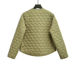 Detail of olive green quilted jacket featuring unique heart-shaped stitching patterns