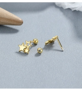 Macro view of gold three-star silver earrings with secure screw back closure