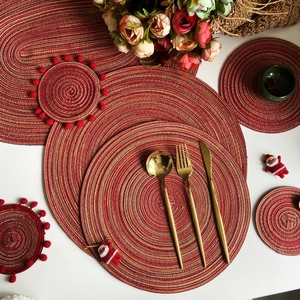 Nordic red and gold woven round place mats with festive pom-pom coasters and decor
