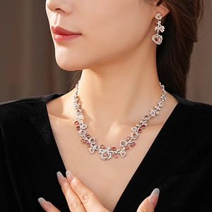 Detail of vintage rose jewelry set with orange gemstones and diamonds on model