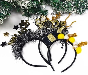 Close-up of 2025 New Year party headbands with silver tassels and champagne bottle motifs