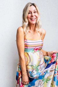 Detail of vibrant tropical print dress featuring Oceania motifs and palm tree patterns