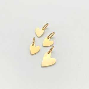 Macro detail of four polished gold heart pendants for DIY jewelry making accessories