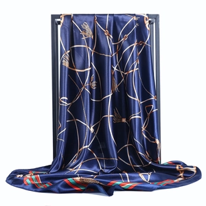 Deep blue satin square scarf with golden equestrian chain print and elegant drape