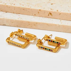 Detail of gold rectangular earrings with clear zircons and multi-colored gemstones