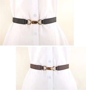 Detail of black and brown elastic waist belts with gold metal buckles on a shirt