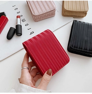Close-up of textured leather lipstick bags in red, pink, khaki, and black colors