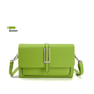 Detail of green crossbody bag showing woven texture and silver rectangular metal buckle