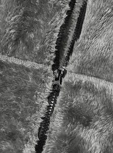 Macro shot of durable black zipper and thick polar fleece texture on warm winter jacket