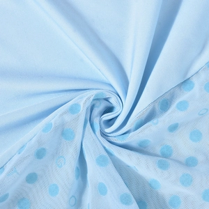 Detail of light blue mesh fabric featuring flocked polka dots and subtle brand lettering