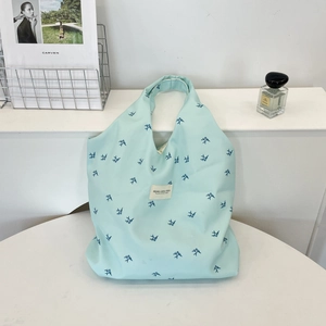 Detail of blue swallow print and white woven label on the canvas tote bag texture