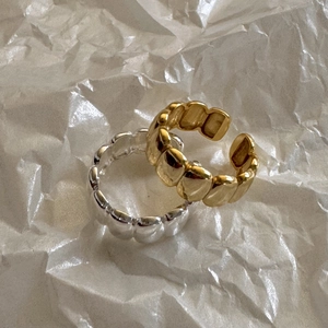 Macro shot of minimalist S925 sterling silver oval rings in gold and silver finishes