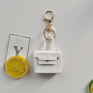 Detailansicht weißer Mini-Taschen-Schlüsselanhänger aus PU-Leder mit goldenem Metallclip