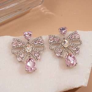 Vue macro des boucles d'oreilles nœud en cristal avec pierre rose en goutte d'eau