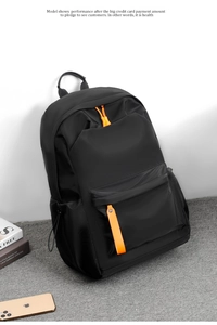 Detail of waterproof black oxford backpack with orange zipper pull and front pocket