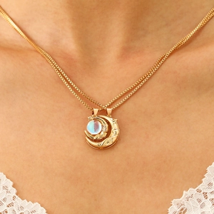 Detailed view of a gold-plated crescent moon pendant necklace with a moonstone inlay on a model
