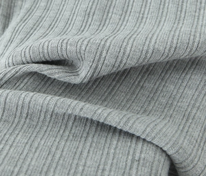 Gros plan sur un tricot gris à fines côtes montrant la texture douce en coton mélangé