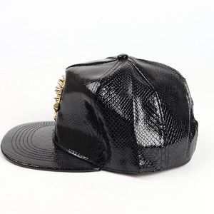 Detail of black faux crocodile leather snapback hat with golden metal cone studs