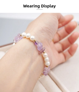 Gros plan d'un bracelet en améthyste violette et perles d'eau douce au poignet d'une femme
