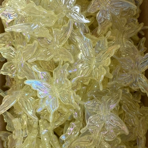 Macro shot of iridescent butterfly charms with translucent rainbow finish for DIY jewelry