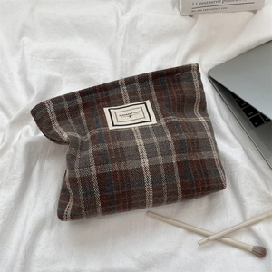 Detail of vintage plaid wool fabric and woven label on a portable cosmetic storage bag