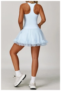 Detail of light blue racerback yoga top and layered mesh tennis skirt from back view
