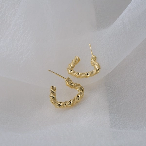 Elegant 18K gold plated twisted hoop earrings with 925 silver needles on white silk