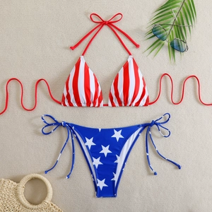 Flat lay of US flag bikini with red stripes and star patterns on a woven mat