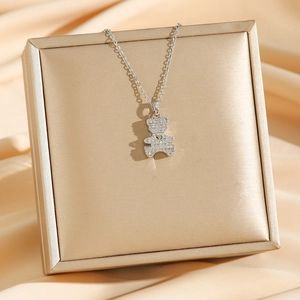Silver bear necklace with micro-paxed zircons and heart detail on champagne silk