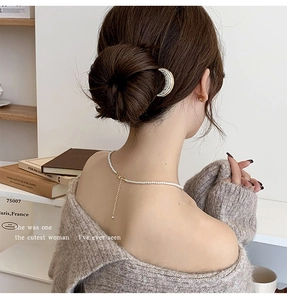 Elegant U-shaped hair pin with rhinestones and pearls for a sophisticated low bun hairstyle