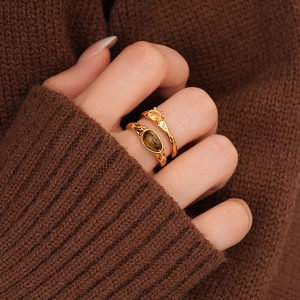 Detail of 18k gold plated tiger eye and zircon double layer rings worn with a knit sweater