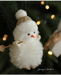 Close-up of plush snowman pendant with ski gear on a festive Christmas tree background